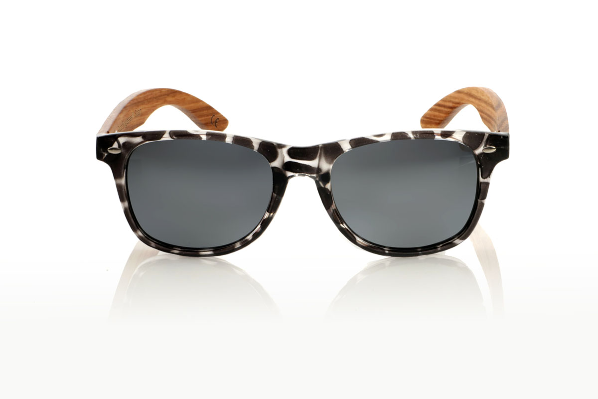 Wood eyewear of Walnut KHUN. KHUN are the new must-have for sunglasses lovers. With its design inspired by the classics, these glasses feature a transparent Tortoiseshell frame in a palette of gray and black with a satin gloss finish, bringing a modern mix to an iconic style. The Walnut temples not only contrast beautifully with the frame, but also add a touch of warmth and naturalness. Perfect for any occasion, the KHUN offers clear vision and protection without compromising style. With measurements of 152x49 and a caliber of 54, they fit perfectly, promising comfort and an impeccable look to those who wear them. for Wholesale & Retail | Root Sunglasses® 